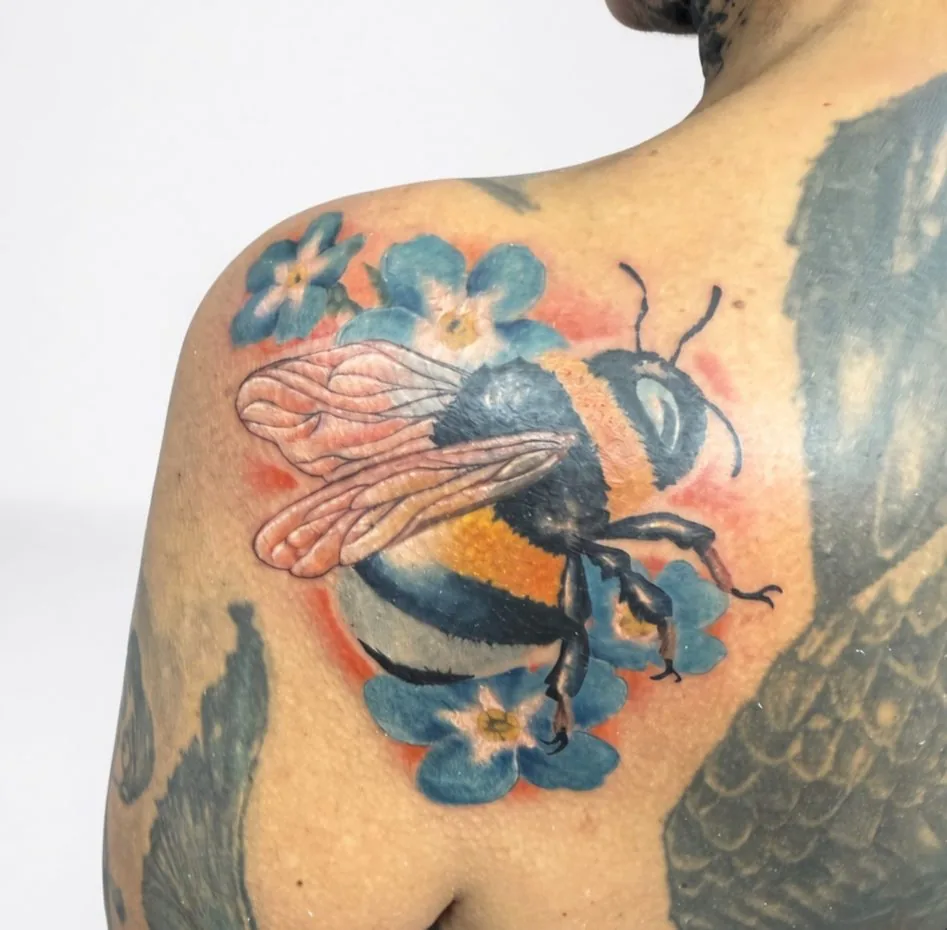 Farbtattoo einer Hummel mit Vergissmeinnicht-Blüten